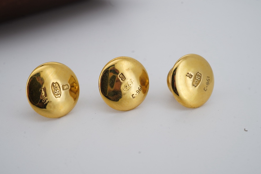 A set of three gold dress studs, each of circular outline in polished gold, approximately 7mm diameter each, each marked 18ct, combined gross weight 3 grams, fitted case